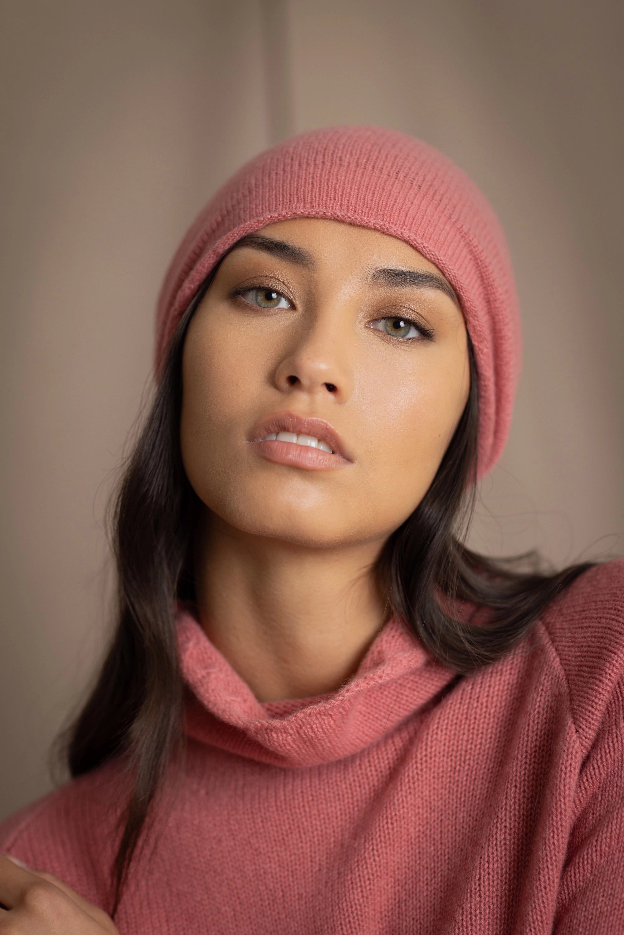 a woman wears a cashmere beanie hat in dusty rose pink