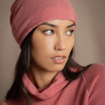a woman wears a cashmere beanie hat in dusty rose pink