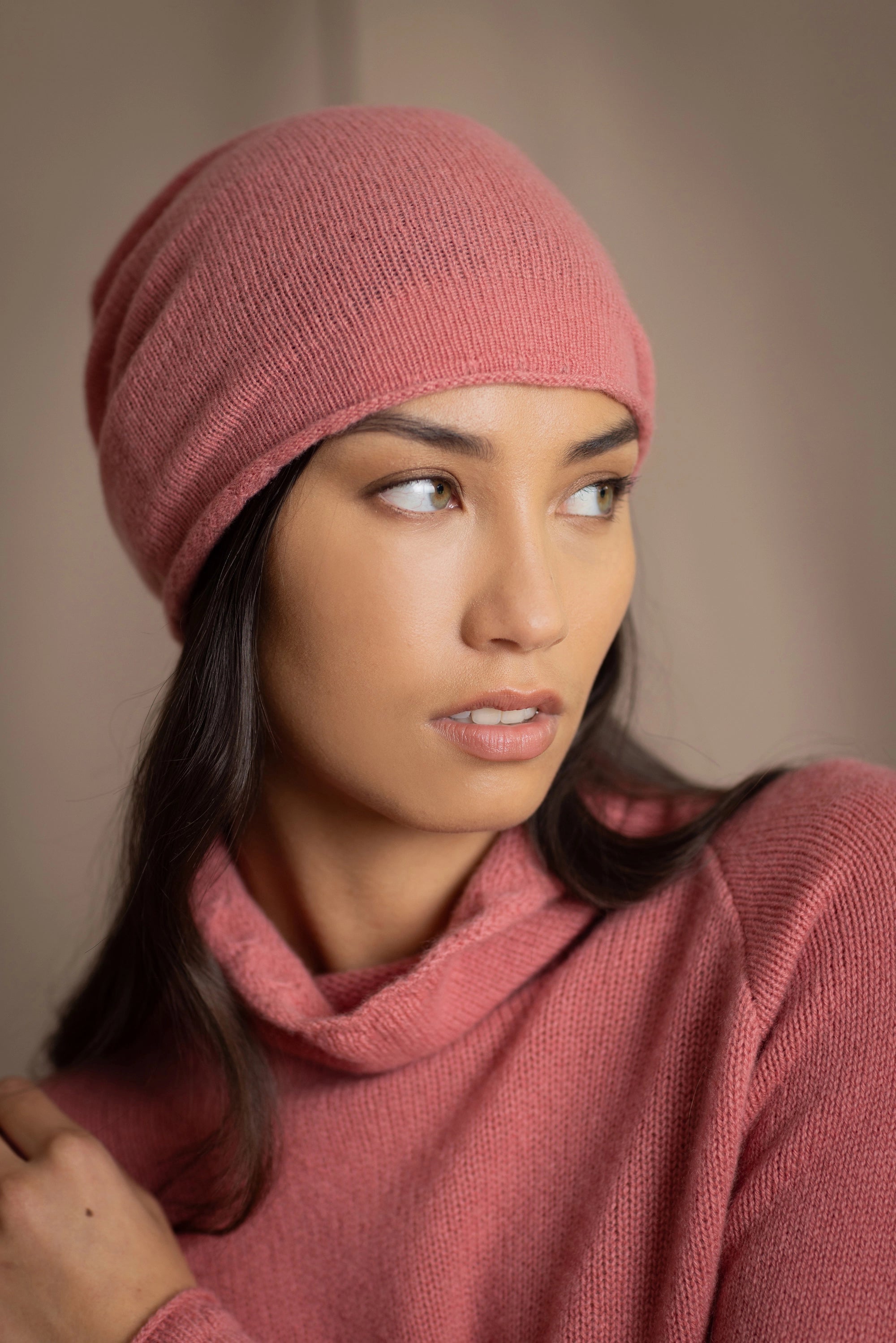 a woman wears a cashmere beanie hat in dusty rose pink