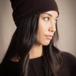 a woman wears a cashmere beanie hat in dark brown