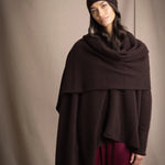 a woman wearing a large cashmere wrap shawl in dark brown with matching cashmere beanie hat