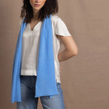 A woman wears a 100% silk v-neck t-shirt in white with a blue cashmere scarf and a pair of jeans
