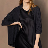 a woman wearing a large sparkling cashmere wrap shawl in black