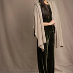 Woman wearing a beige cashmere wrap in beige with gold metallic lurex over green velvet outfit