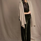 Woman wearing a beige cashmere wrap in beige with gold metallic lurex over green velvet outfit