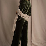 Woman wearing a beige cashmere wrap in beige with gold metallic lurex over green velvet outfit