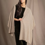 Woman wearing a beige cashmere wrap in beige with gold metallic lurex over green velvet outfit