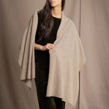 Woman wearing a beige cashmere wrap in beige with gold metallic lurex over green velvet outfit