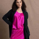 a long shawl open cashmere cardigan in black paired with bright neon pink silk top and skirt