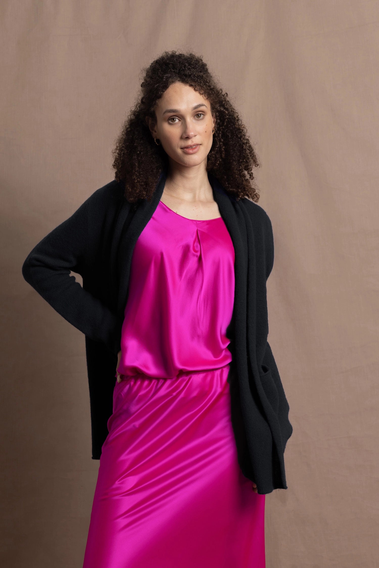 a long shawl open cashmere cardigan in black paired with bright neon pink silk top and skirt