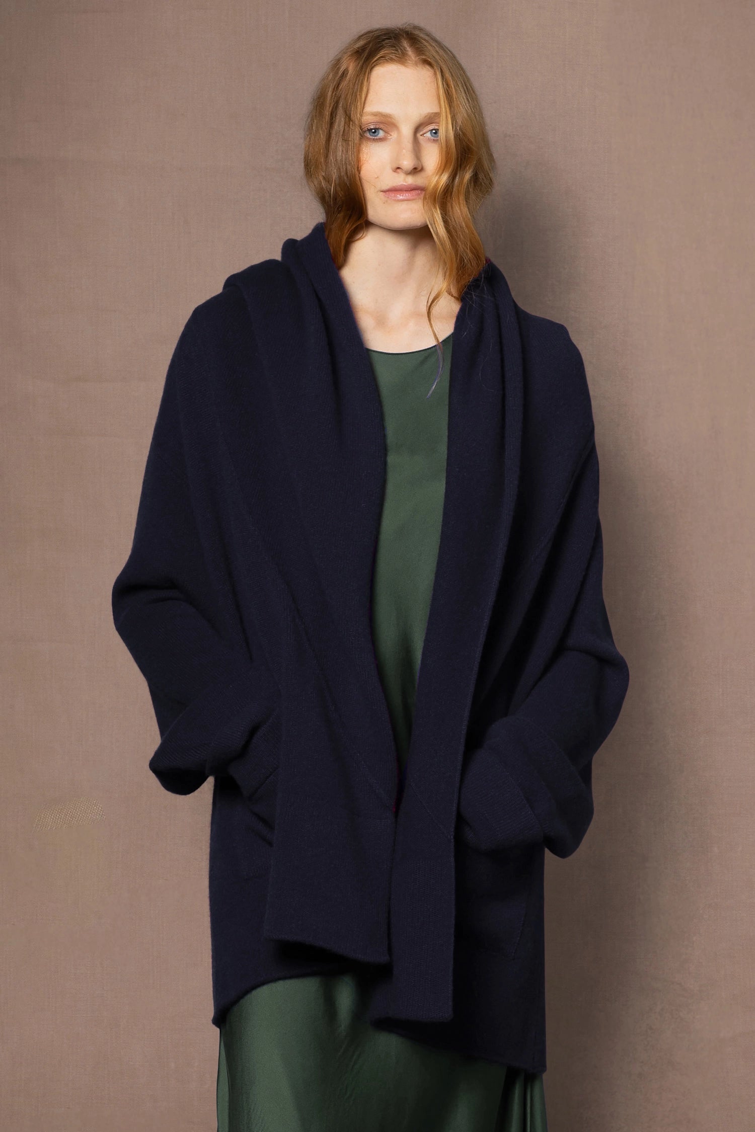 woman wearing ink blue cashmere coat cardigan over green silk dress