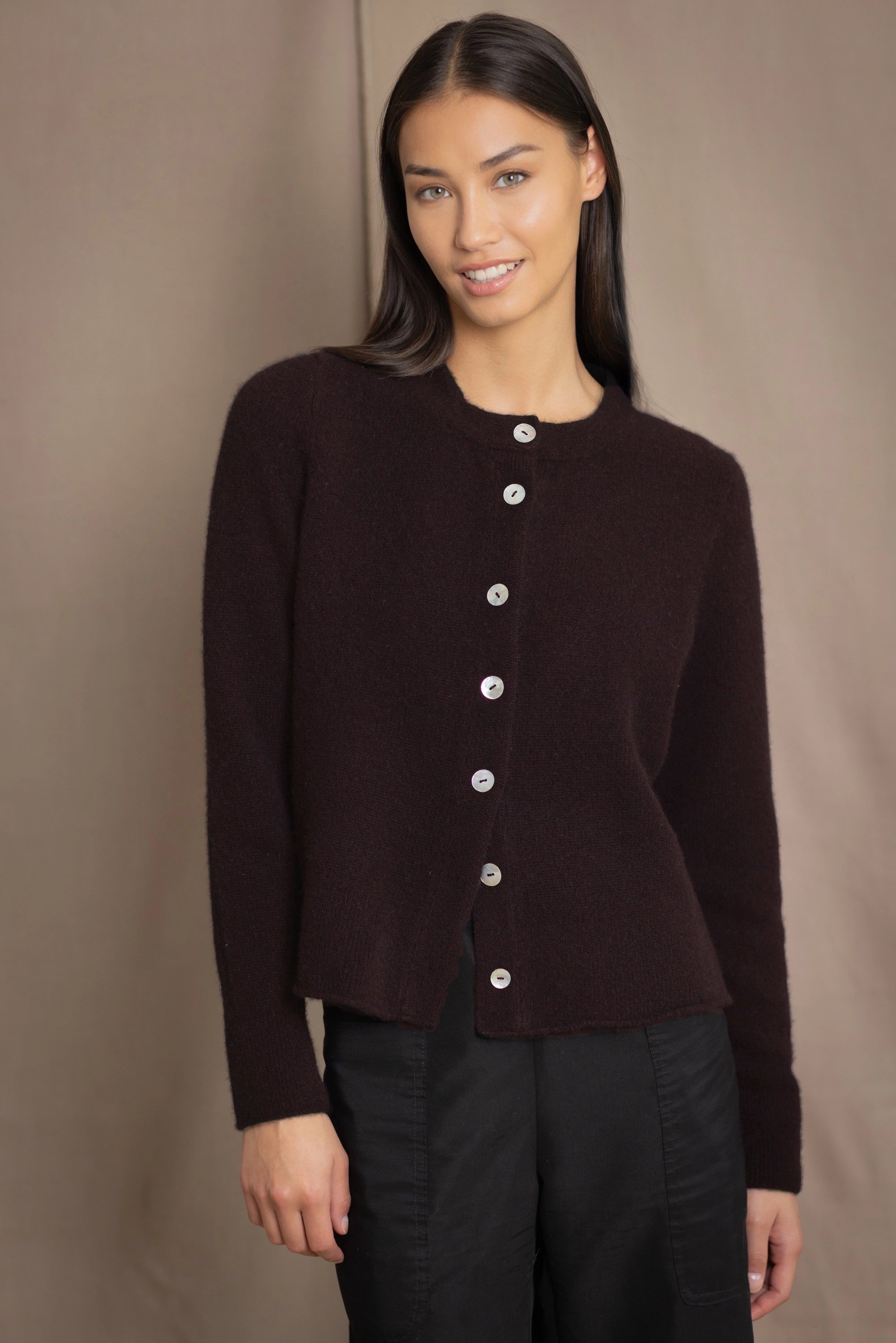 Woman wearing a dark brown cashmere cardigan with mother of pearl buttons