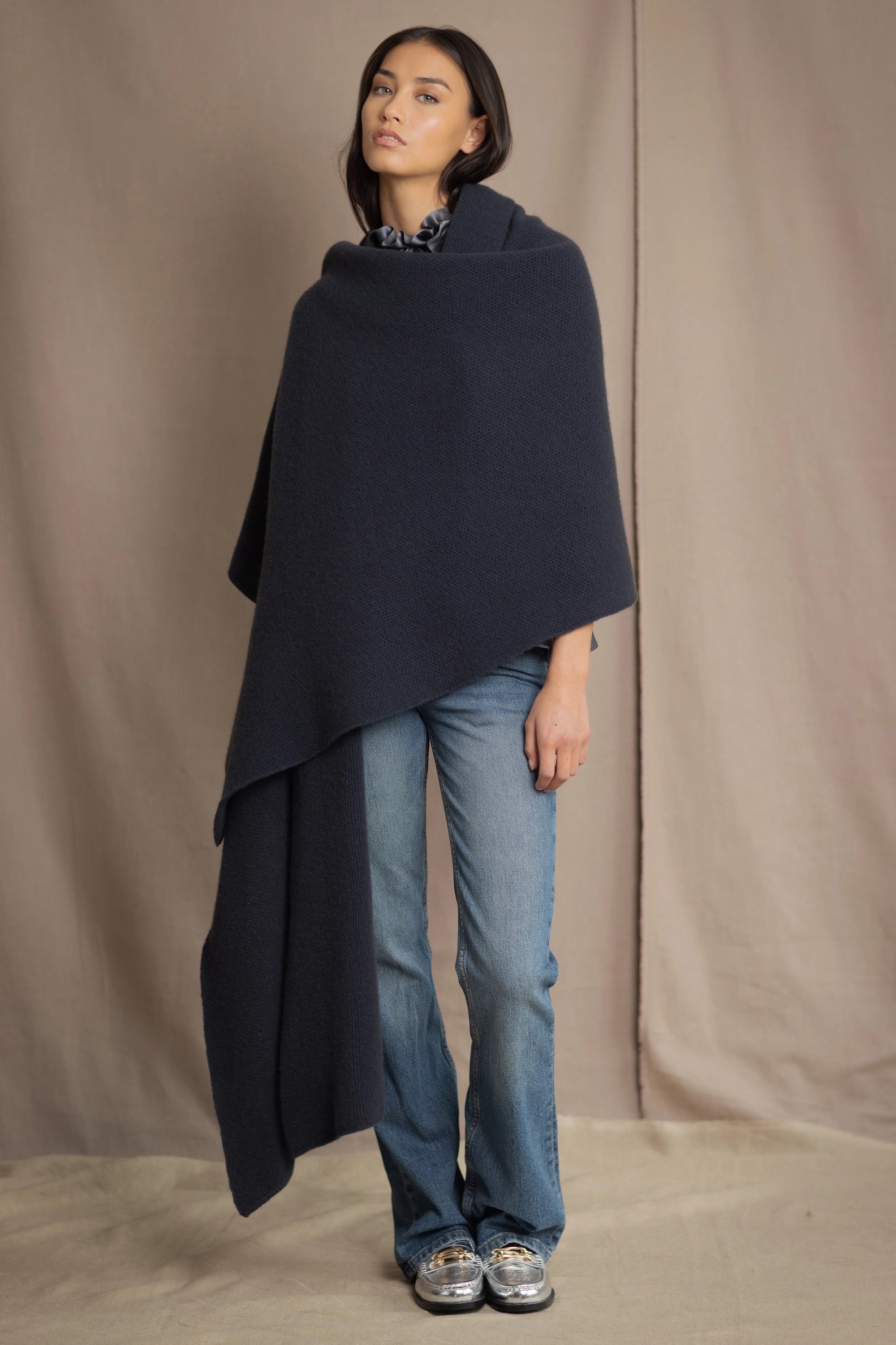 a woman wears a large cashmere blanket wrap shawl in ink blue