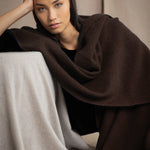 Woman wearing a brown cashmere wrap shawl over a black top