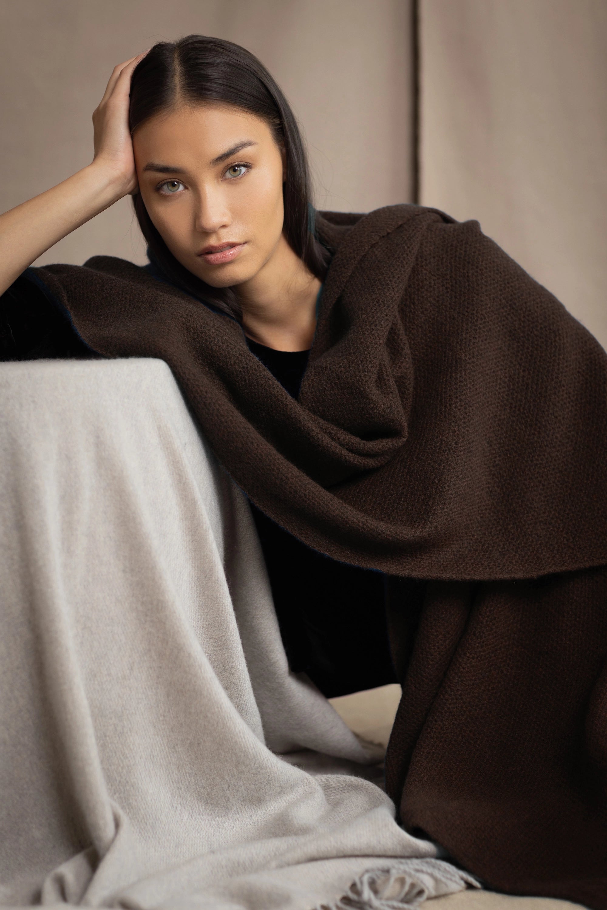 Woman wearing a brown cashmere wrap shawl over a black top