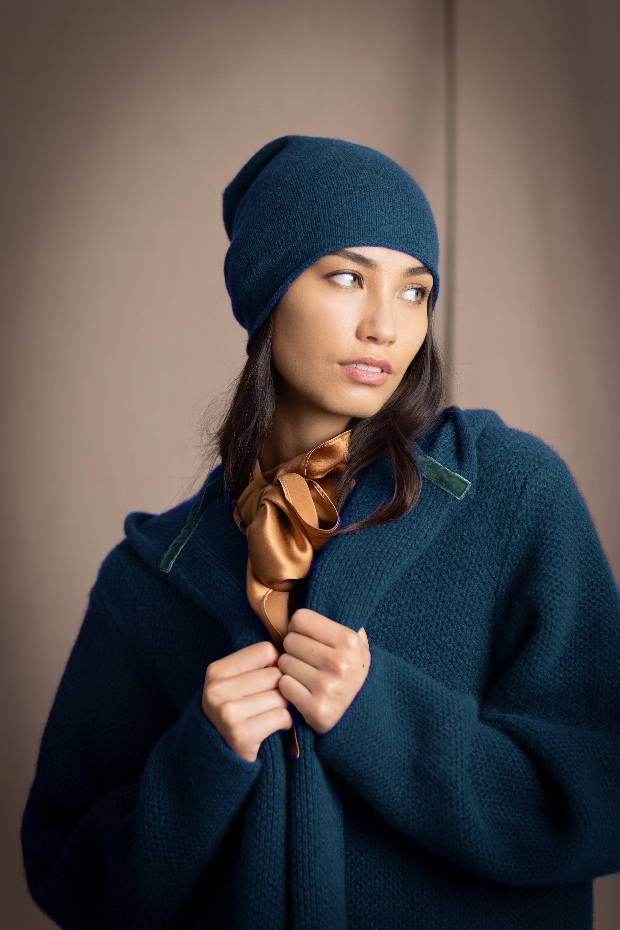 Woman wearing a blue teal cashmere coat and cashmere hat