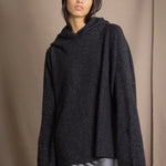 woman wearing an oversized cashmere sweater with hood in black and silver sparkly metallic colour