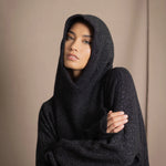 woman wearing an oversized cashmere sweater with hood in black and silver sparkly metallic colour