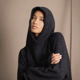 woman wearing an oversized cashmere sweater with hood in black and silver sparkly metallic colour