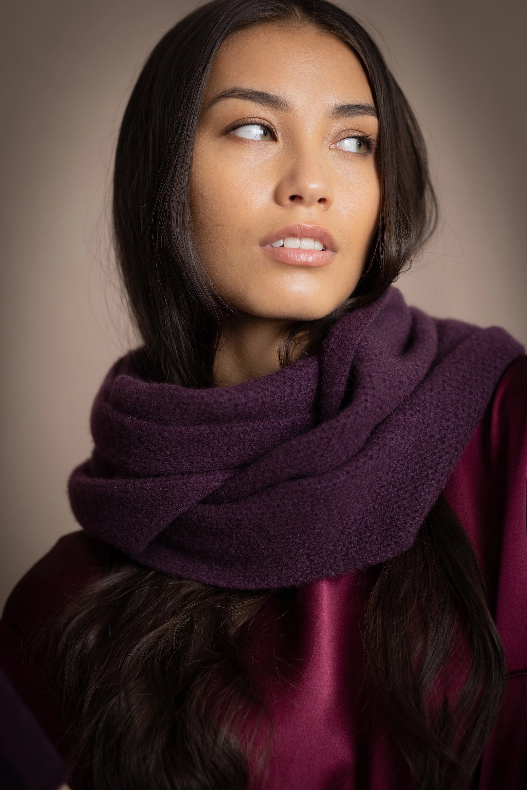 a woman wearing a cashmere snood in dark purple over burgundy silk top