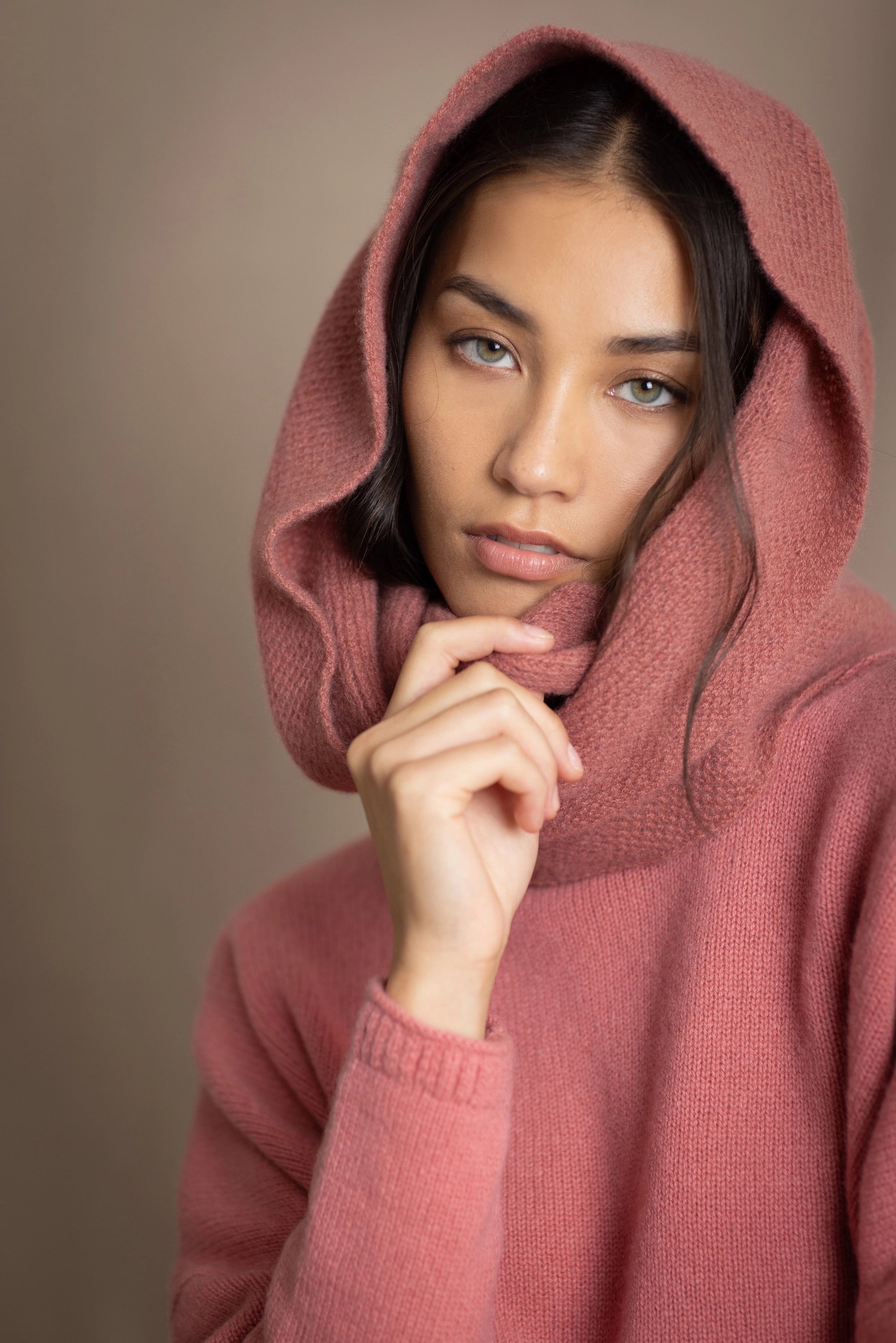 a woman wearing a cashmere snood in dusty rose pink over a matching cropped sweater