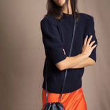 woman wearing a vegan leather pouch crossbody bag in navy metallic