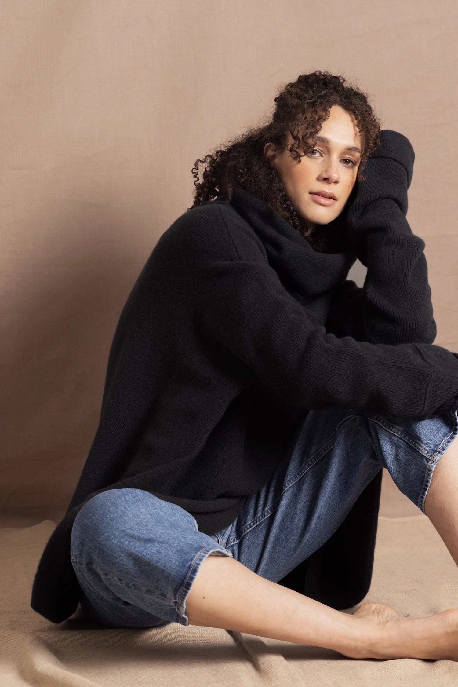 A woman wears an oversized 100% cashmere sweater in black