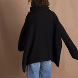 A woman wears an oversized 100% cashmere jumper in black
