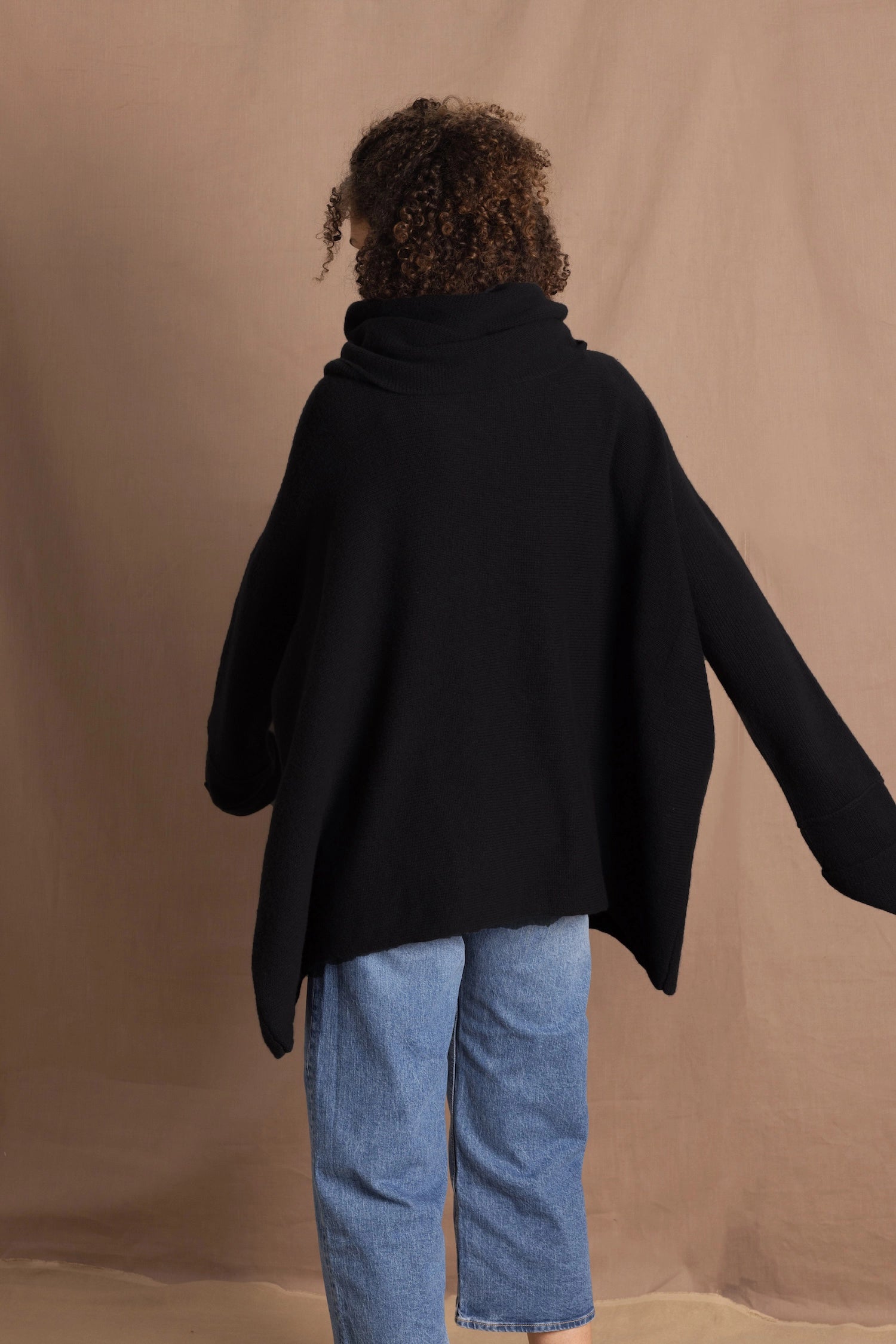 A woman wears an oversized 100% cashmere jumper in black