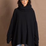 A woman wears an oversized 100% cashmere sweater in black