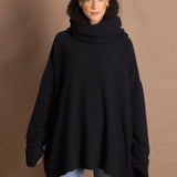 A woman wears an oversized 100% cashmere sweater in black