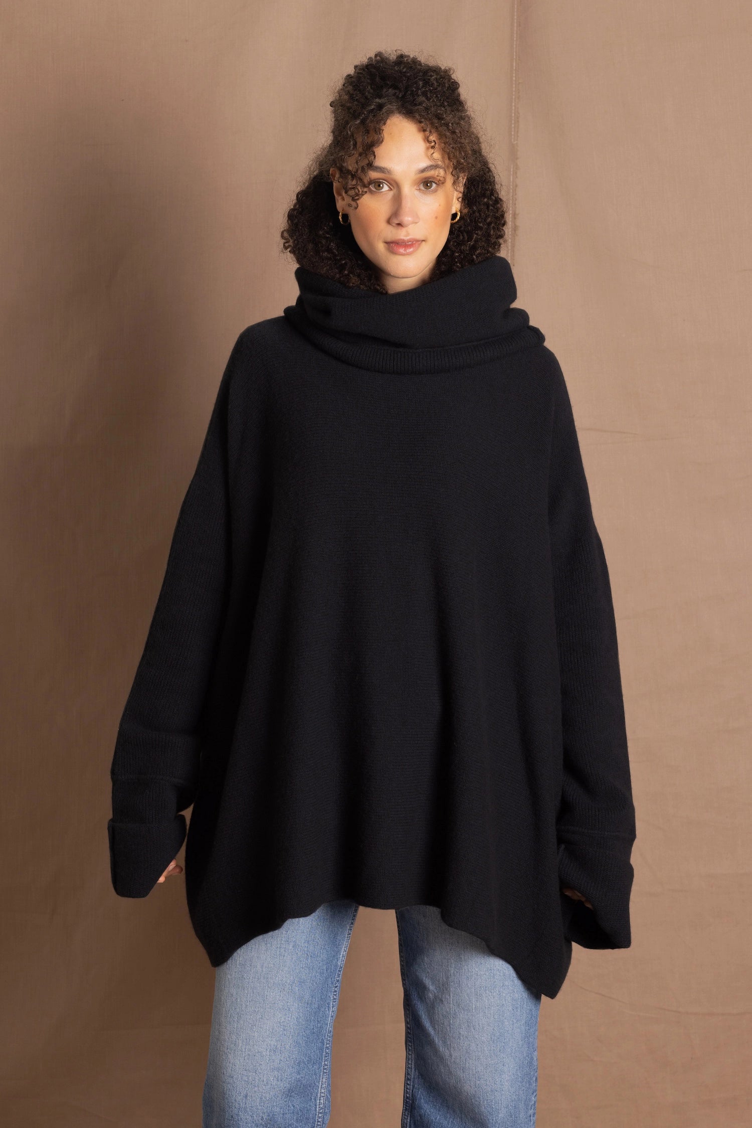 A woman wears an oversized 100% cashmere sweater in black
