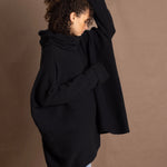 A woman wears an oversized 100% cashmere jumper in black