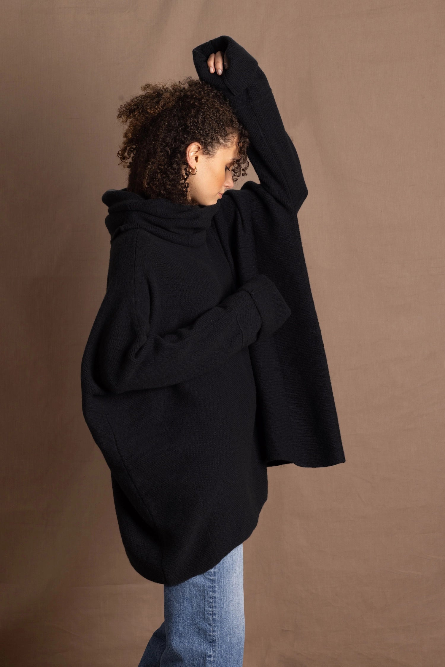 A woman wears an oversized 100% cashmere jumper in black