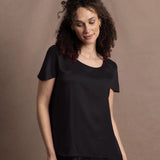 a woman wears a black crew neck short sleeve silk tee and matching trousers