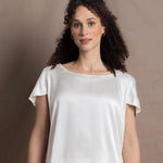 A lady wears a crew neck silk tshirt in white with butterfly sleeves
