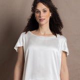 A lady wears a crew neck silk tshirt in white with butterfly sleeves