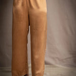 a woman wearing bronze silk pants with an elastic waist