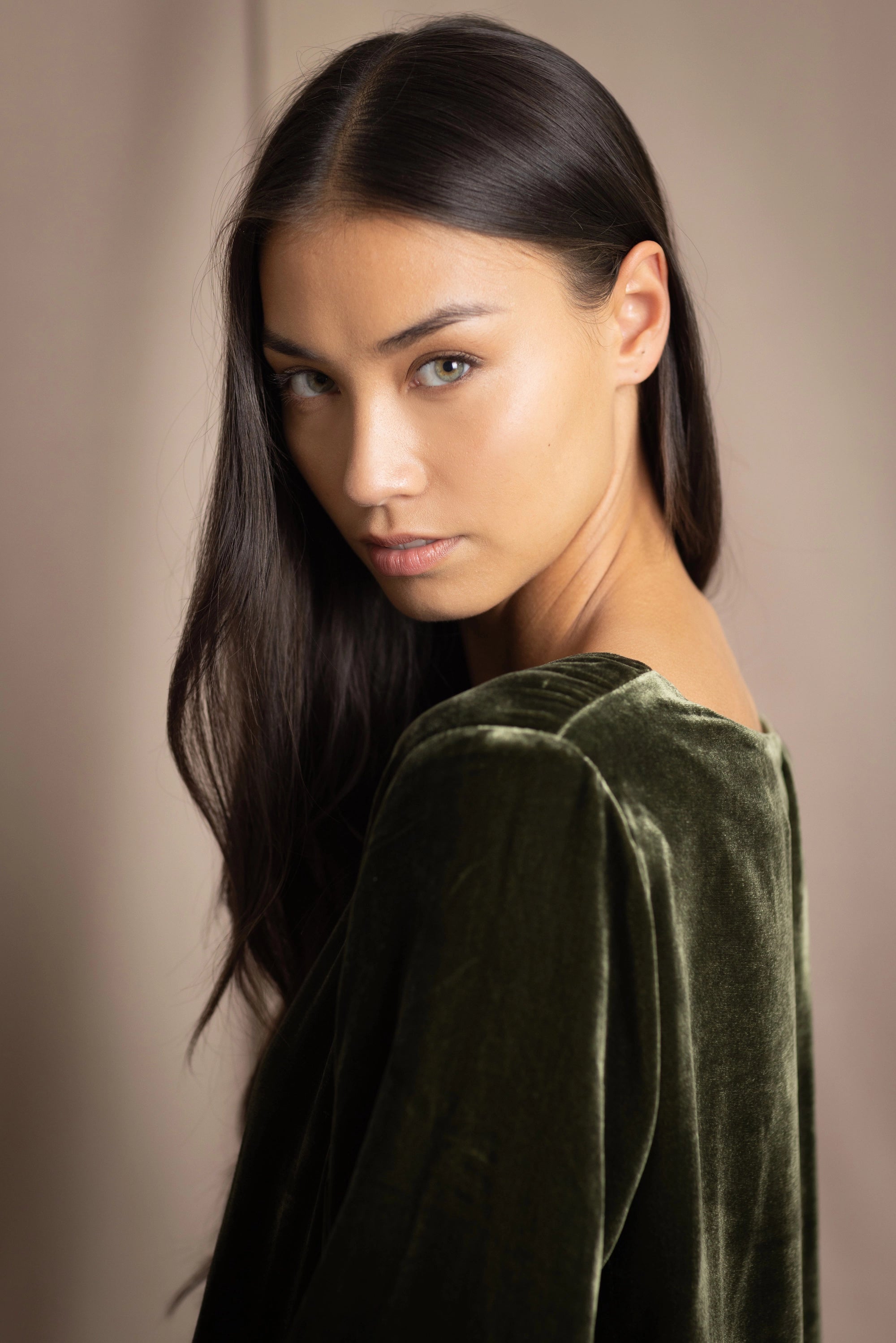 a woman wears a 3/4 sleeve top in silk velvet in olive green