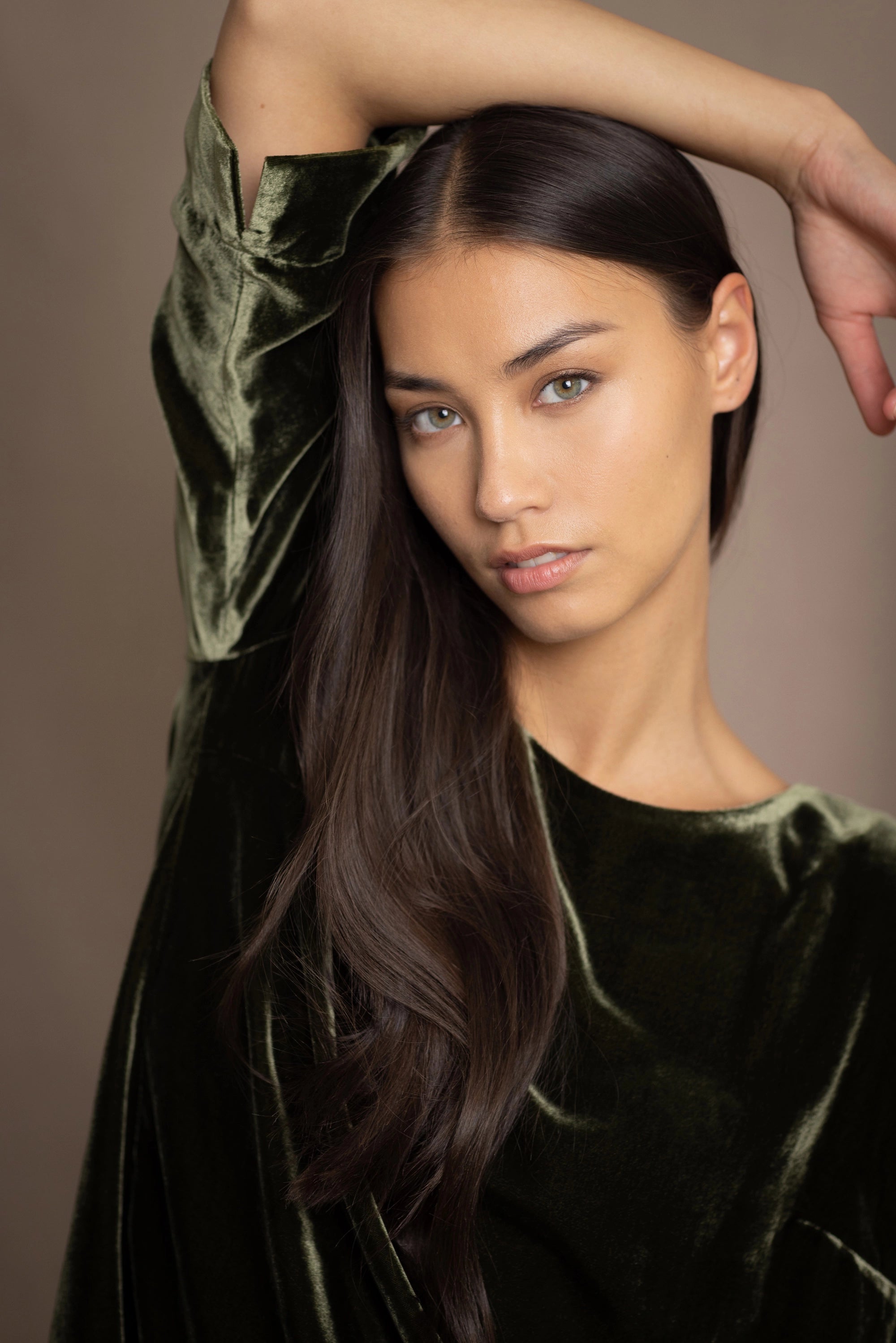a woman wears a 3/4 sleeve top in silk velvet in olive green