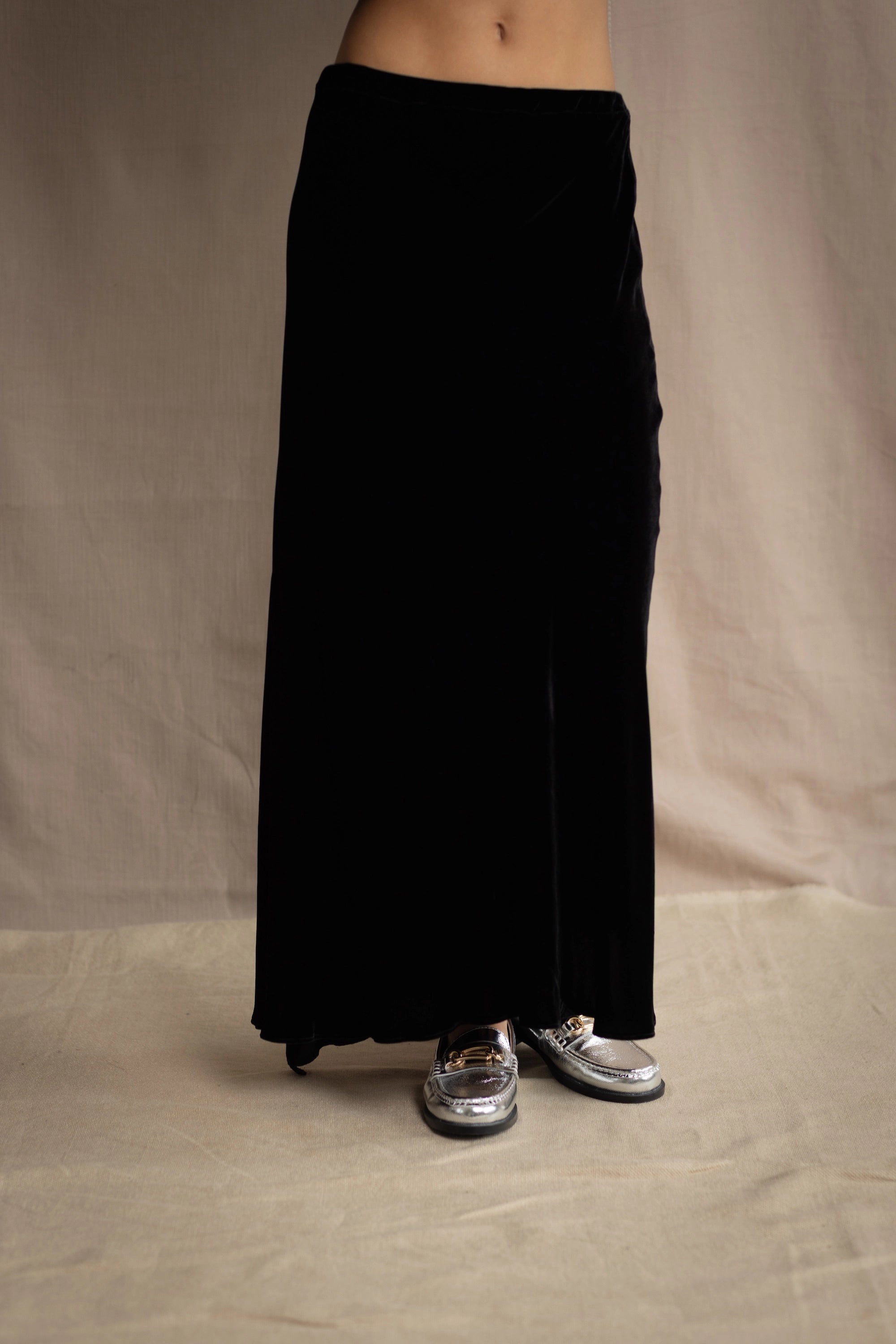 a woman wears a silk velvet skirt in black