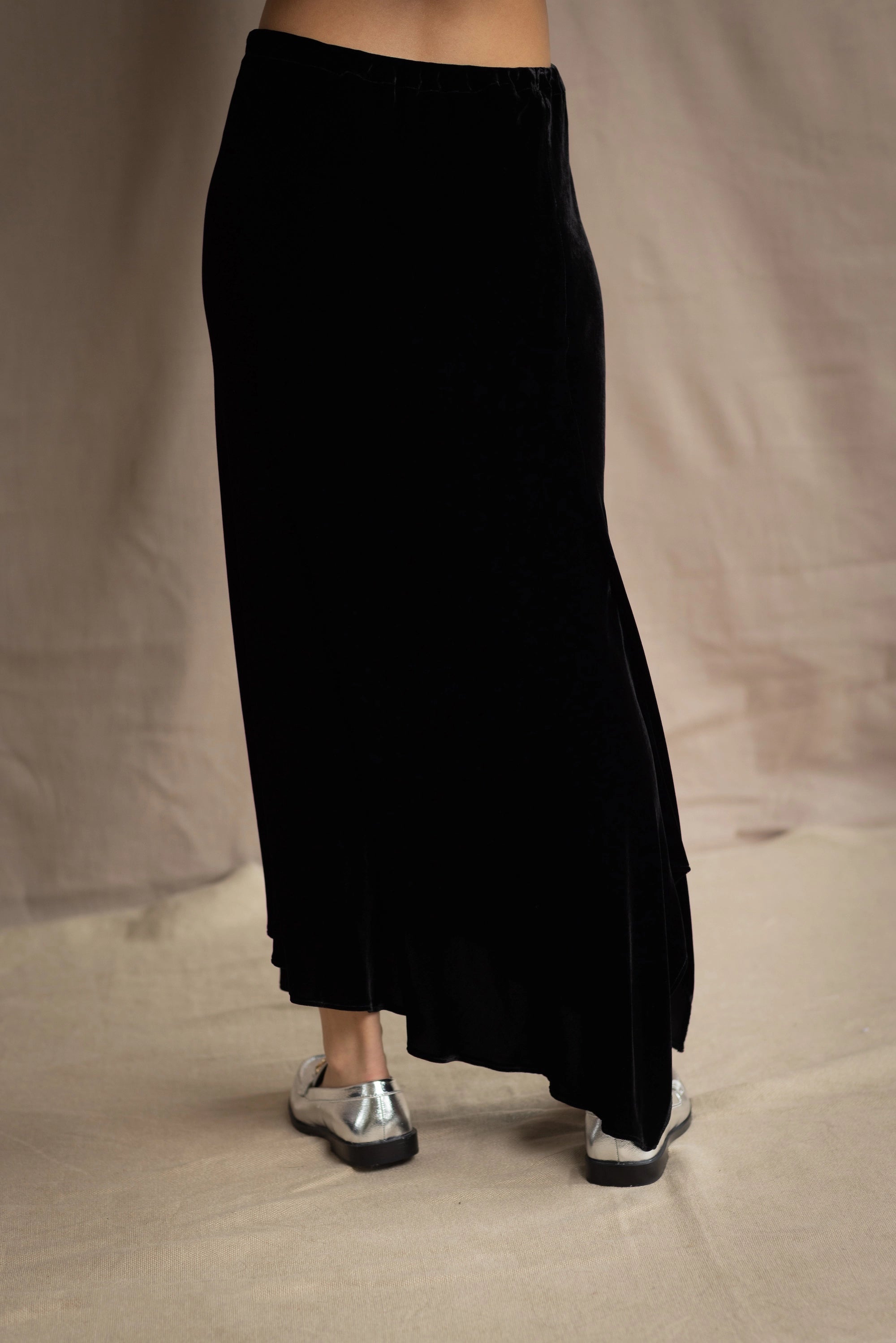 a woman wears a silk velvet skirt in black
