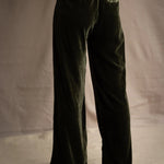 a woman wears silk velvet trousers in olive green with elastic waist