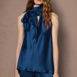 woman wearing sleeveless teal blue top and trousers in silk
