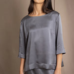 woman wearing a dark grey pewter silk 3/4 sleeve top blouse with matching silk skirt