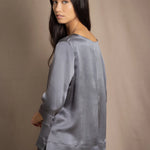 woman wearing a dark grey pewter silk 3/4 sleeve top blouse with matching silk skirt