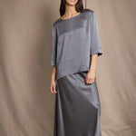 woman wearing a dark grey pewter silk 3/4 sleeve top blouse with matching silk skirt