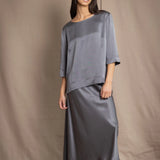 woman wearing a dark grey pewter silk 3/4 sleeve top blouse with matching silk skirt