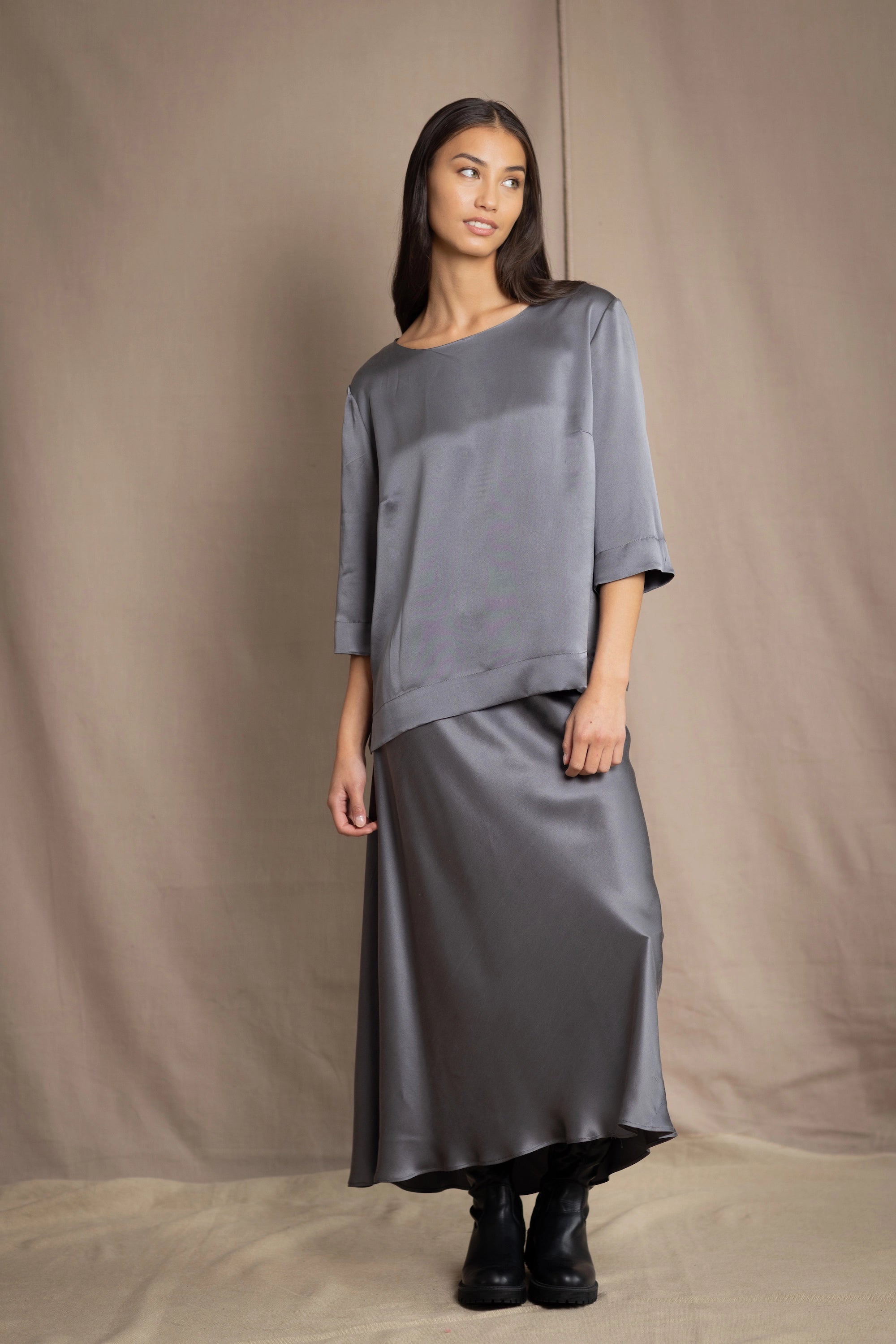 woman wearing a dark grey pewter silk 3/4 sleeve top blouse with matching silk skirt