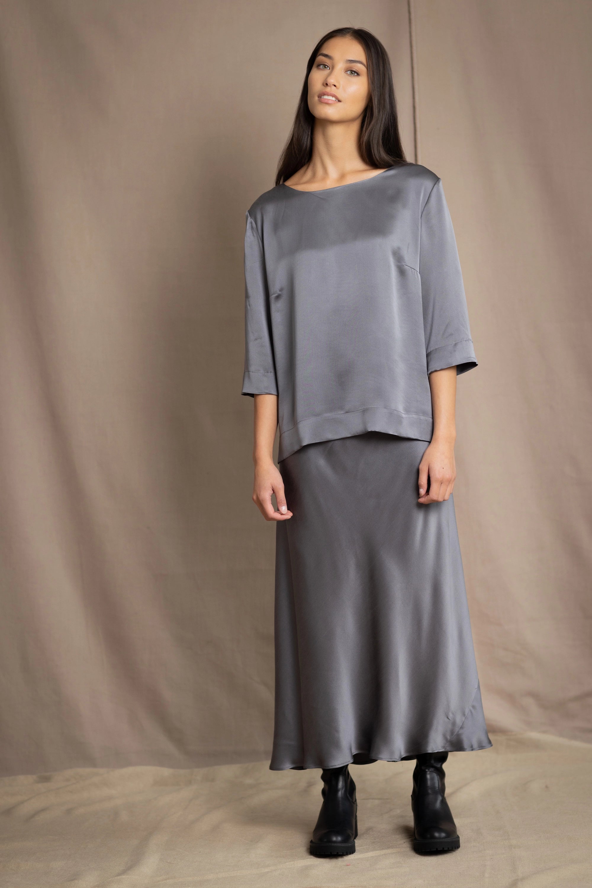 woman wearing a dark grey pewter silk 3/4 sleeve top blouse with matching silk skirt
